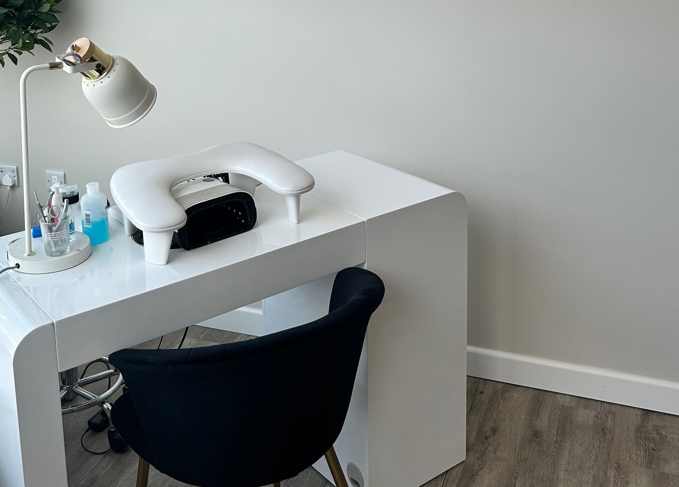Modern nail station at Megan’s Beauty, Norwich, England, GB with white desk and plush chair.