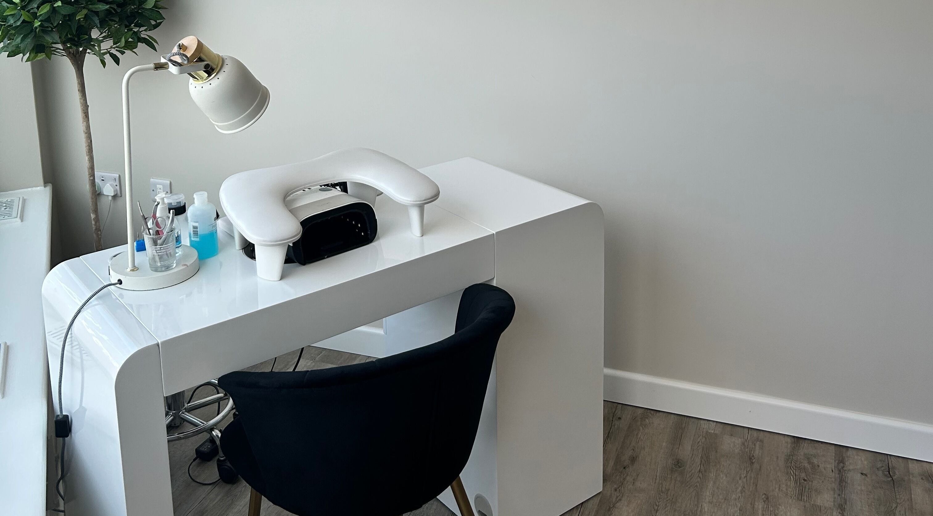 Modern nail station at Megan’s Beauty, Norwich, England, GB with white desk and plush chair.