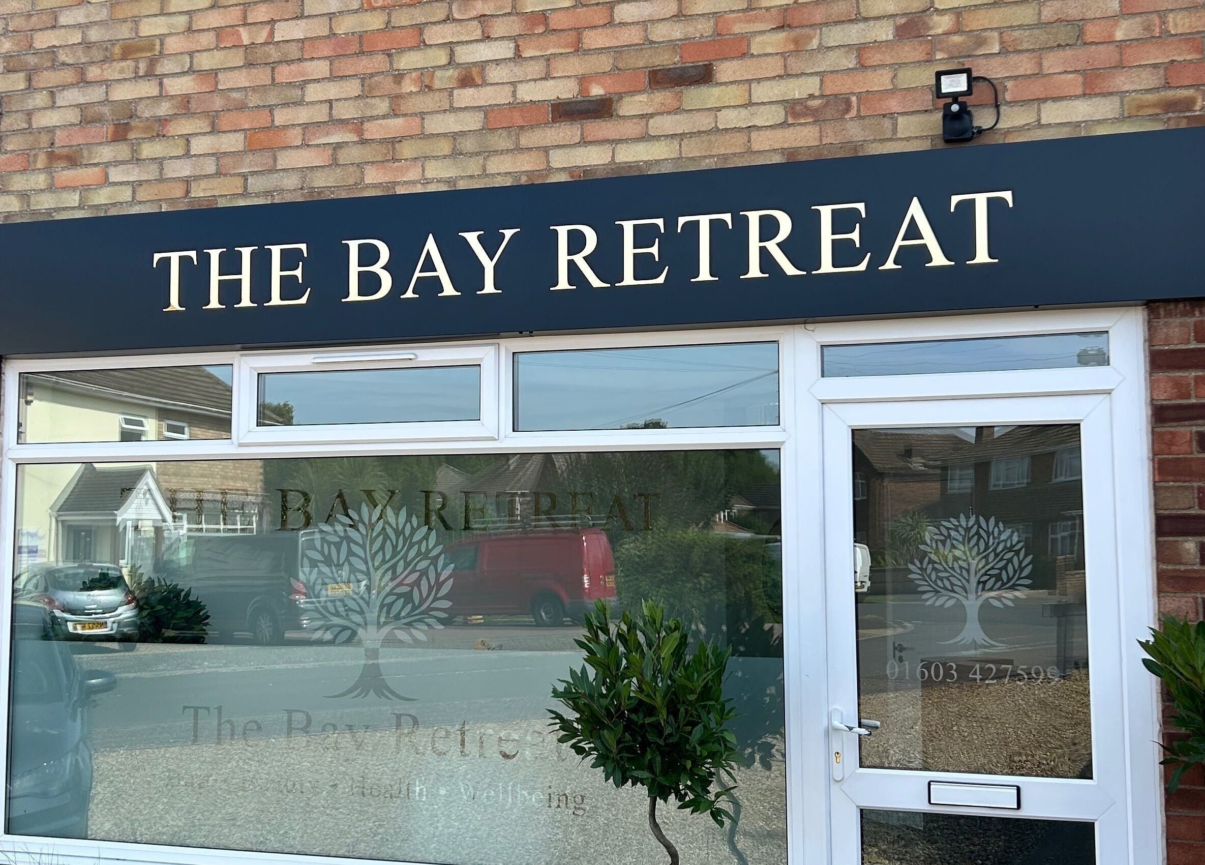 Front of Megan’s Beauty in Norwich, England, GB with elegant signage and potted plants.