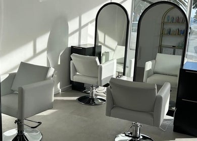 Modern salon chairs at Alchemy Hair & Beauty in Cape Town, Western Cape, ZA with sleek mirrors.
