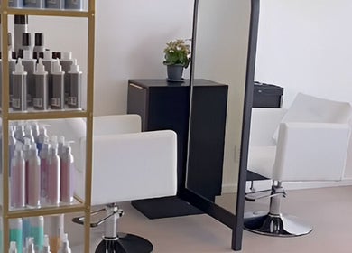 Modern salon station at Alchemy Hair & Beauty, Cape Town, Western Cape, ZA. Stylish chairs and product display.