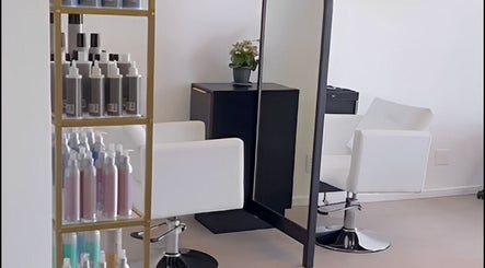Modern salon station at Alchemy Hair & Beauty, Cape Town, Western Cape, ZA. Stylish chairs and product display.