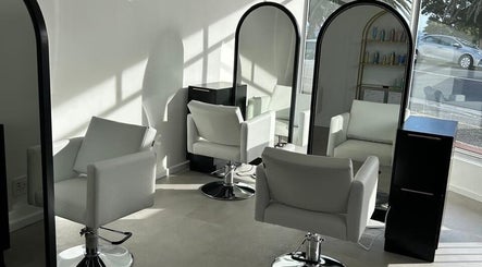 Modern salon setup at Alchemy Hair & Beauty, Cape Town, Western Cape, ZA featuring sleek white chairs and mirrors.