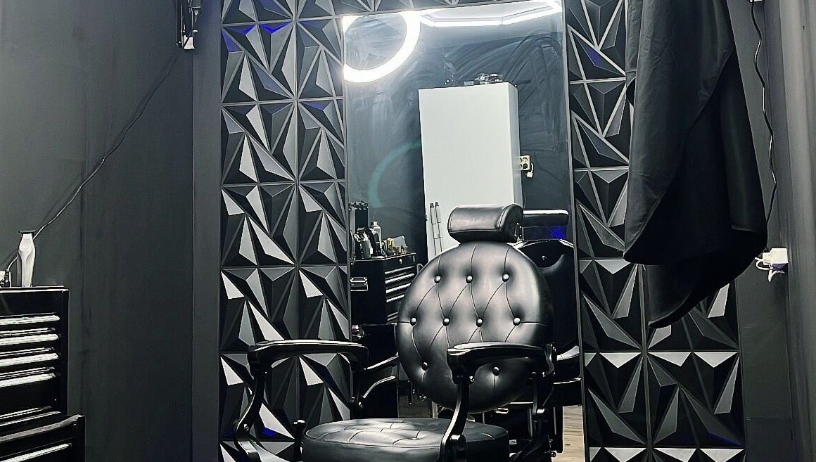 Stijlvolle kappersstoel bij No. 97 | Barber in Eersel, Noord-brabant, NL, tegen een moderne geometrische muur.