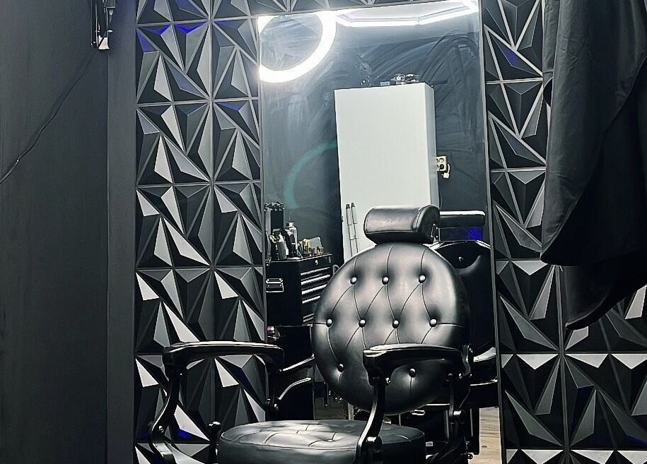 Stijlvolle kappersstoel bij No. 97 | Barber in Eersel, Noord-brabant, NL, tegen een moderne geometrische muur.