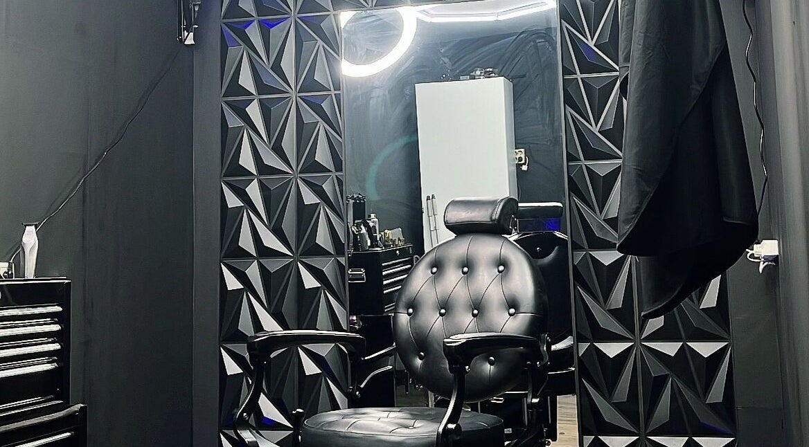 Stijlvolle kappersstoel bij No. 97 | Barber in Eersel, Noord-brabant, NL, tegen een moderne geometrische muur.