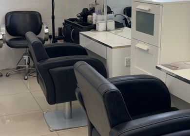 Elegant salon setup at Suki Hair and Beauty in Blackburn, England, GB featuring stylish black chairs.