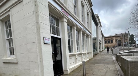 Exterior of Suki hair and beauty in Blackburn, England, GB showcasing elegant salon facade on a cloudy day.