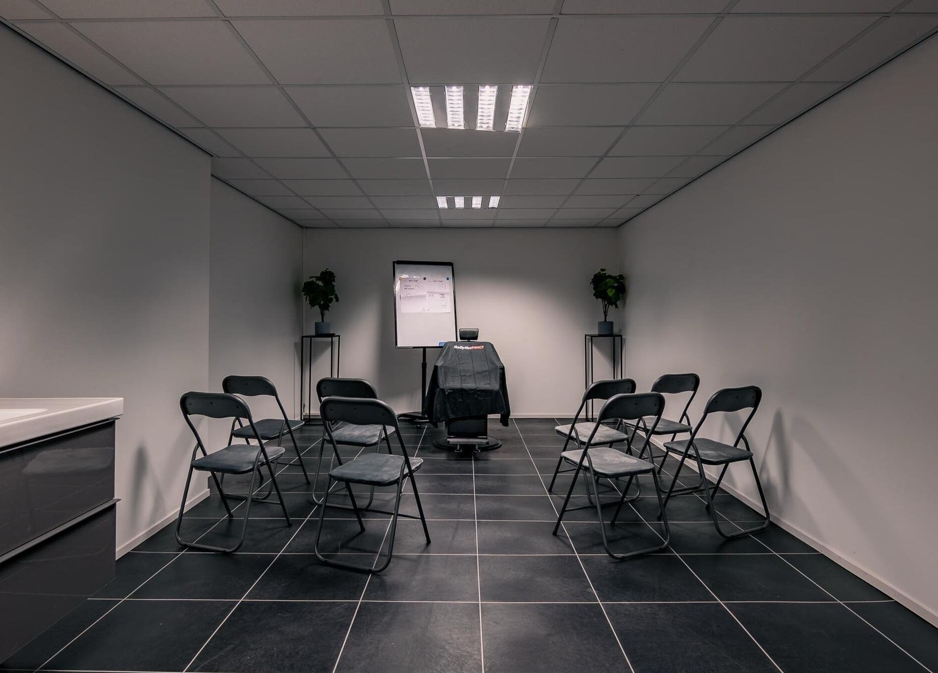 Moderne trainingsruimte bij Darios Academy, Haarlem, Noord-holland, NL met stoelen en flip-over.