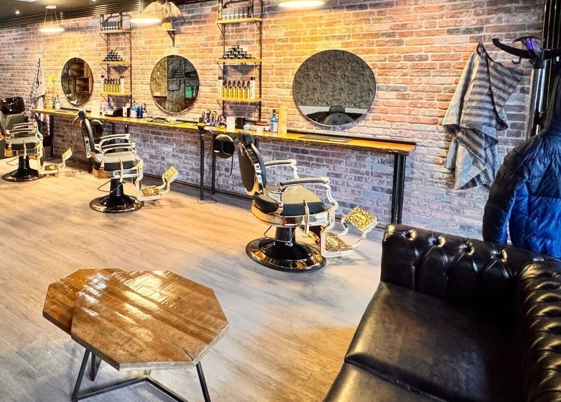 Interieur van Barber Gold in Enschede, Overijssel, NL met moderne kappersstoelen en spiegelwand.