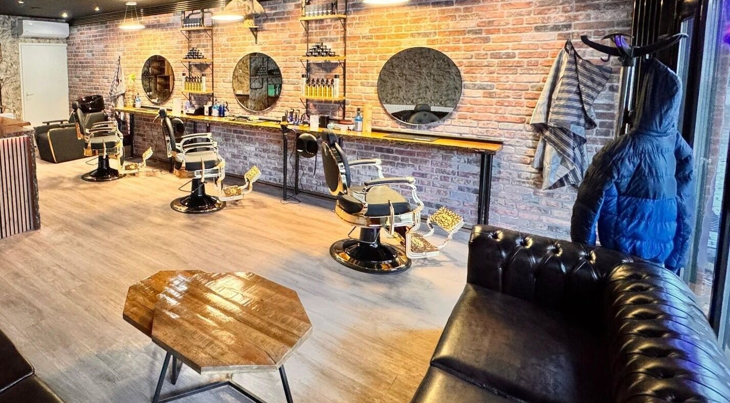 Interieur van Barber Gold in Enschede, Overijssel, NL met moderne kappersstoelen en spiegelwand.