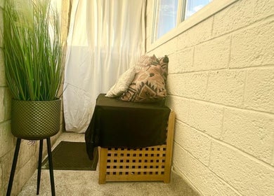 Tranquil corner with cushions and greenery at AJ Beauty in Bath, England, GB, featuring relaxing decor.