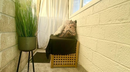 Tranquil corner with cushions and greenery at AJ Beauty in Bath, England, GB, featuring relaxing decor.