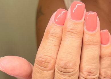 Coral nails manicured at AJ Beauty in Bath, England, GB. Perfect glossy finish for a vibrant look.