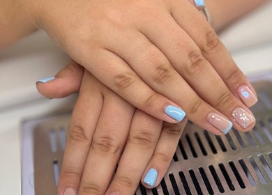 Elegant nail art with pastel blue tips at AJ Beauty, Bath, England, GB showcasing delicate hand care.