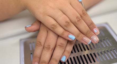 Elegant nail art with pastel blue tips at AJ Beauty, Bath, England, GB showcasing delicate hand care.
