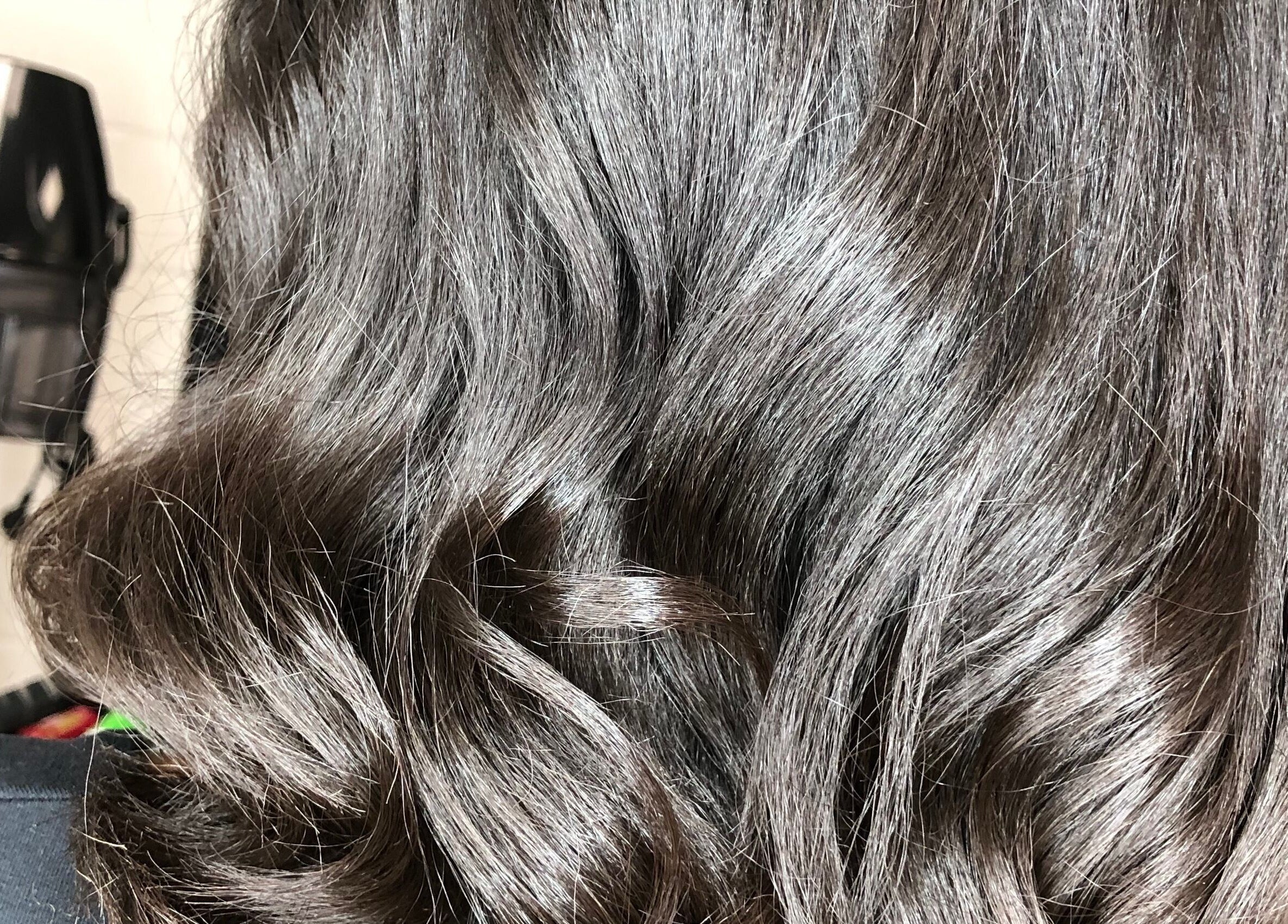 Shiny, wavy hair styled at PhedeliaRose in London, England, GB, highlighting salon expertise.