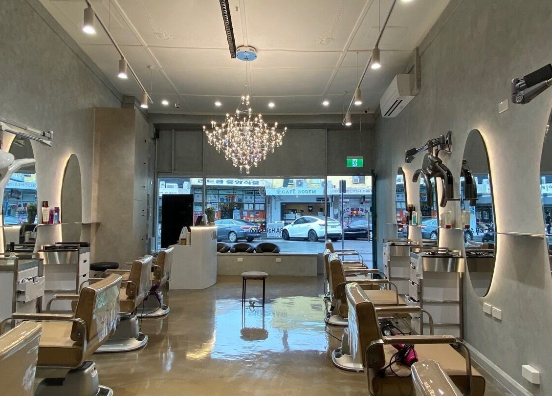 Interior of Ora No1 beauty salon in Lidcombe, New South Wales, AU, featuring elegant chairs and a chandelier.