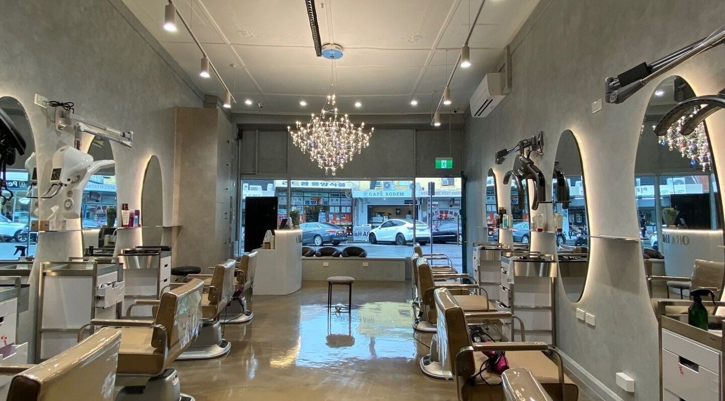 Interior of Ora No1 beauty salon in Lidcombe, New South Wales, AU, featuring elegant chairs and a chandelier.