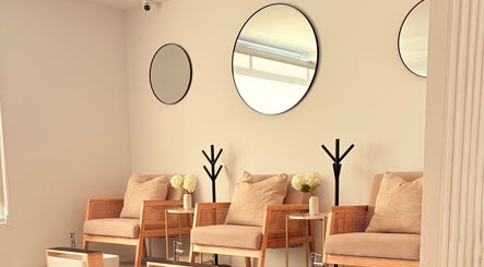 Elegante sala de espera en Aura Nails Salón, Tijuana, Baja California, MX con sillas cómodas y decoración moderna.