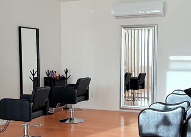 Interior moderno de Aura Nails Salón en Tijuana, Baja California, MX con cómodas sillas negras.