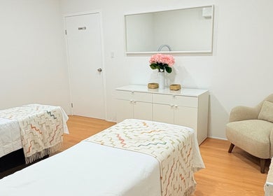 Habitación de spa en Aura Nails Salón, Tijuana, Baja California, MX con cómodas camas y decoración floral.