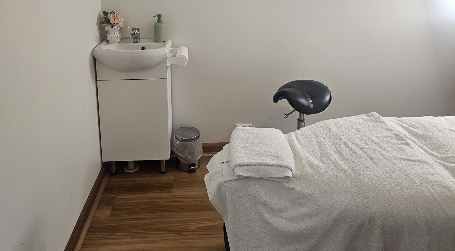 Serene treatment room at KJ Beauty Studio, Mount Helen, Victoria, AU, showcasing a massage table and sink.