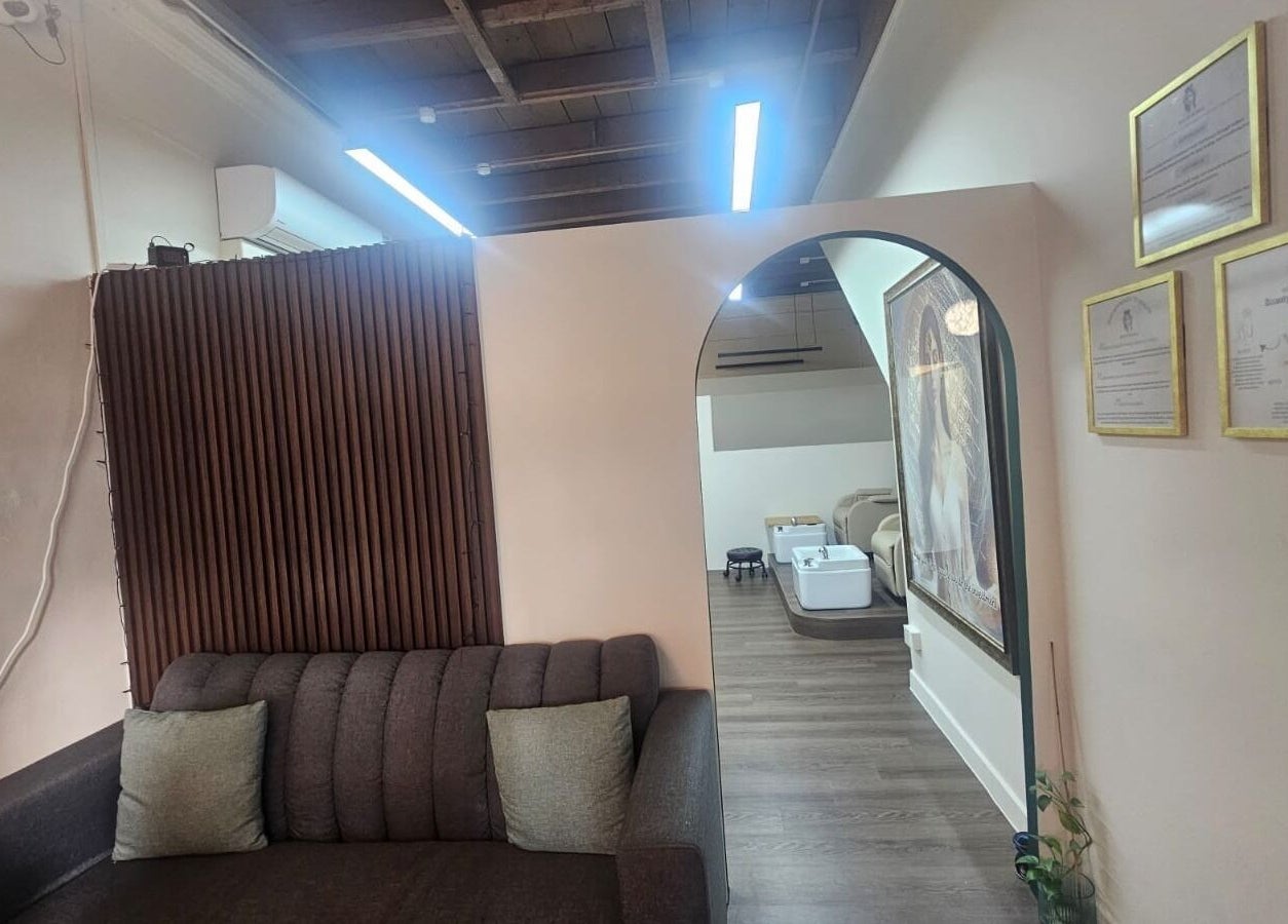 Chic lounge area at Beauty by Devi, Singapore, SG, featuring a plush sofa and calming decor.