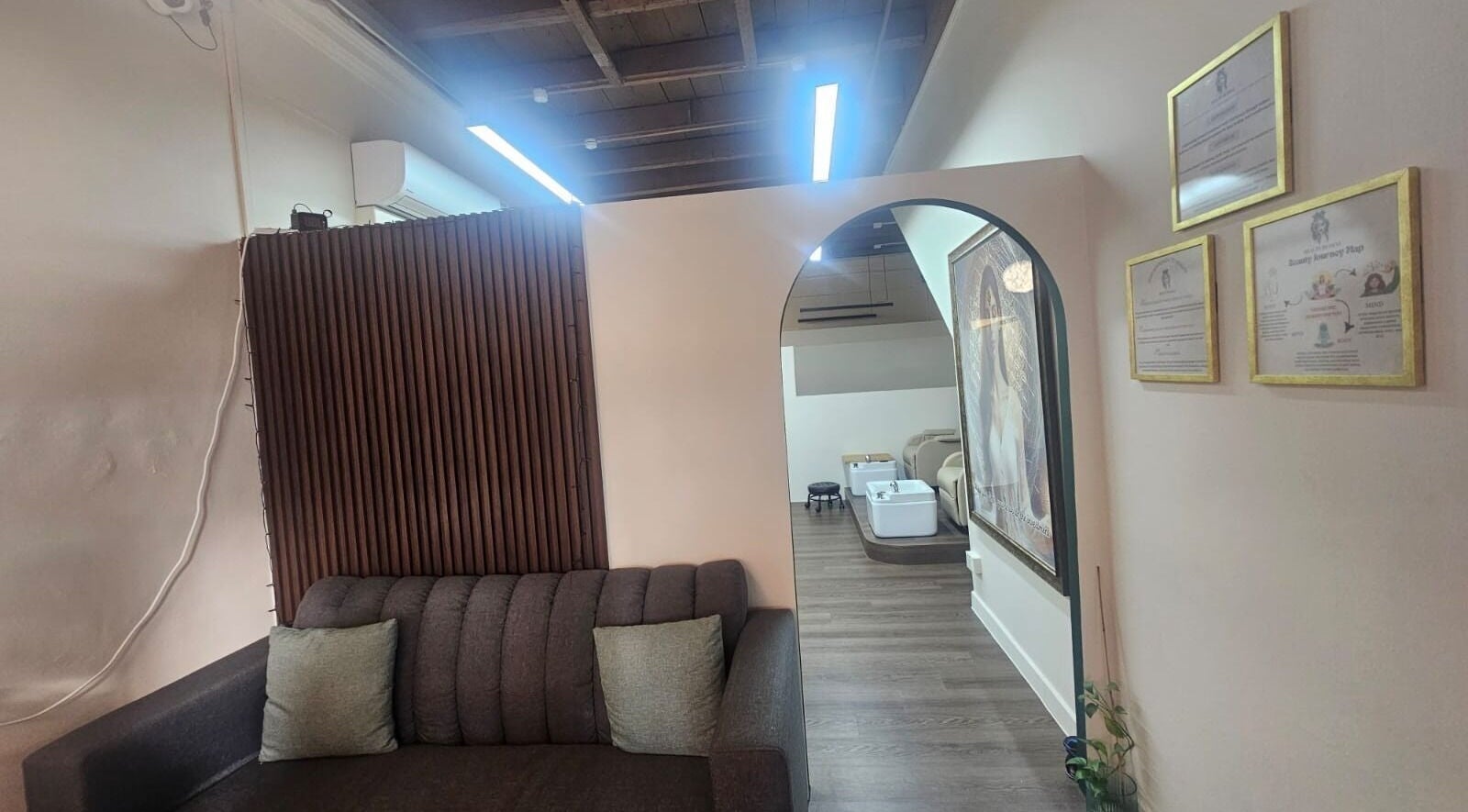 Chic lounge area at Beauty by Devi, Singapore, SG, featuring a plush sofa and calming decor.
