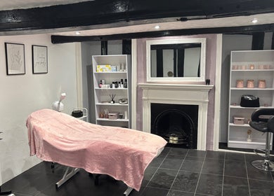 Relaxation area at KM Sculpt & Glow in Congleton, England, featuring a treatment bed and elegant decor.
