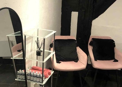 Elegant seating area at KM Sculpt & Glow in Congleton, England, GB with pink chairs and a mirror.