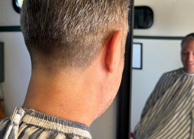Man receives a sharp haircut at Shelly The Barber, Newport, Wales, GB