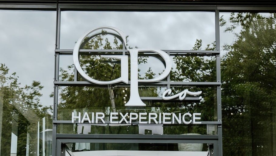 GP Hair Experience entrance in Amsterdam, Noord-Holland, NL with stylish signage and reflections.