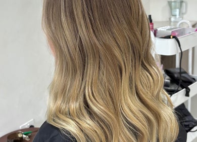 Blonde waves styled at Hair by Holly Stewart in Nambour, Queensland, AU, showcasing vibrant, smooth hair.