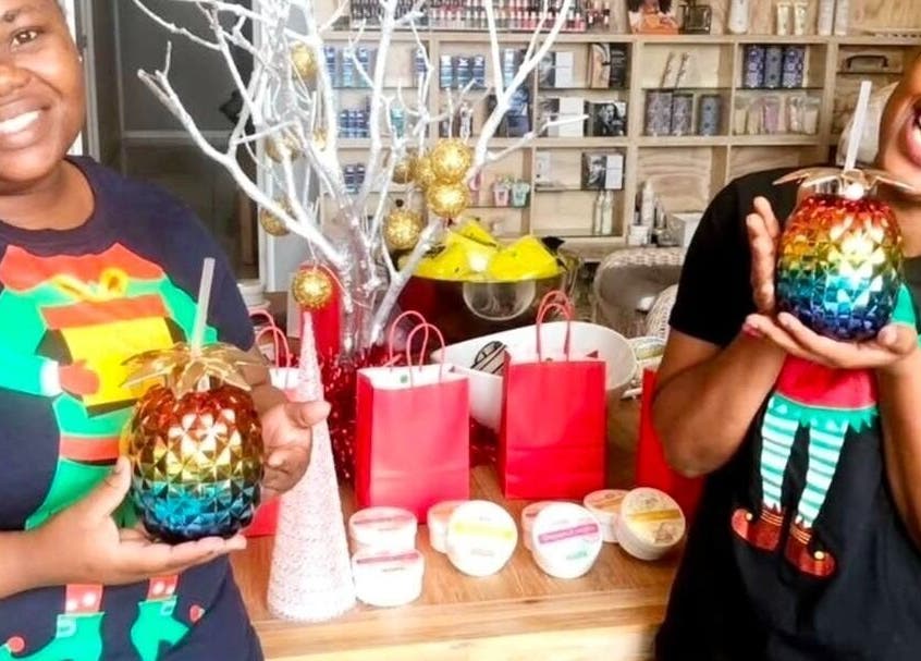 Smiling staff at Tiffany's Beauty Salon, Ballito, Kwazulu-natal, ZA, holding colorful drinks with festive decor.