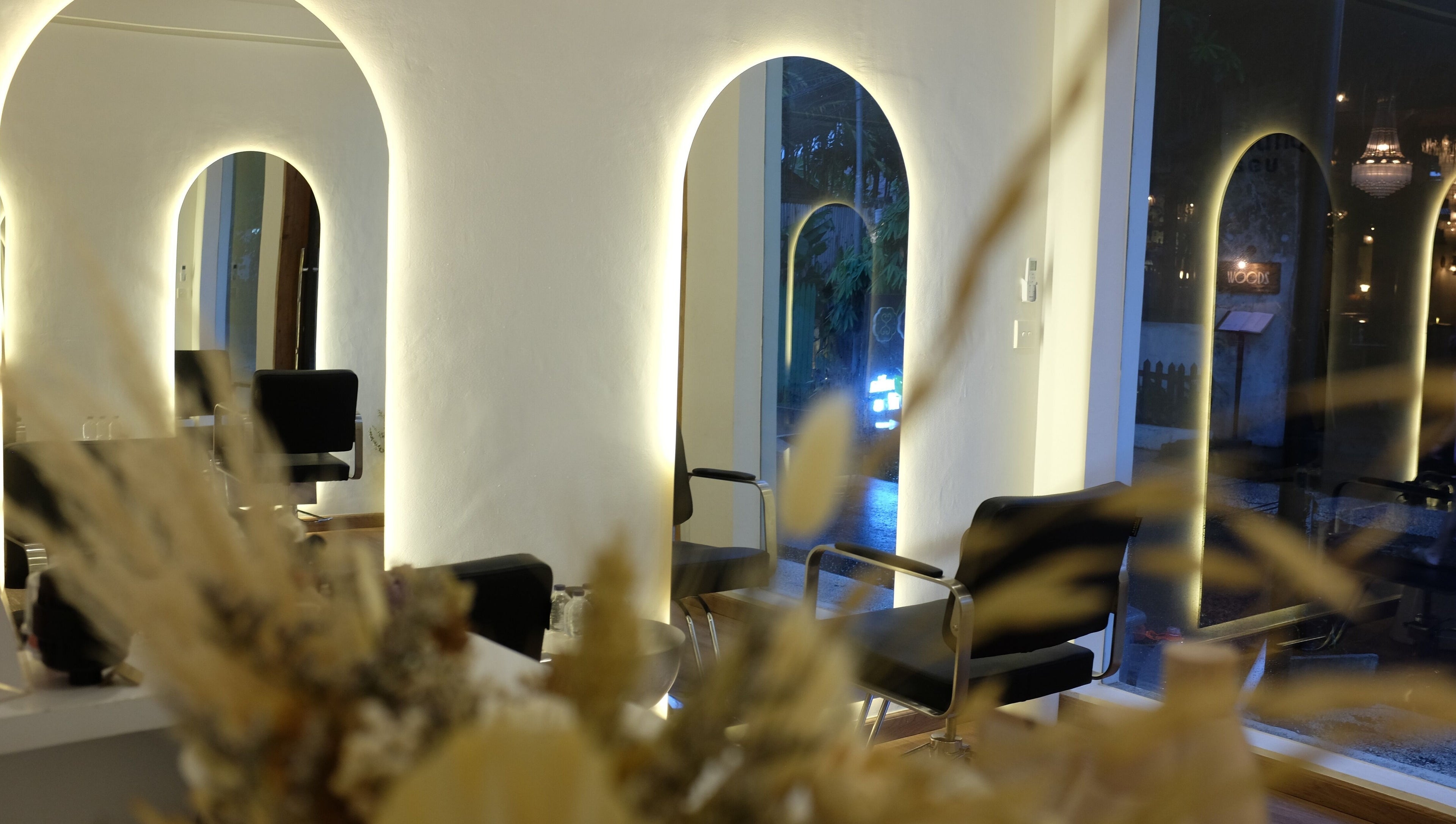 Stylish interior of Blowdry Boutique Canggu, Bali, Bali, ID showcasing chairs and mirrors with warm lighting.