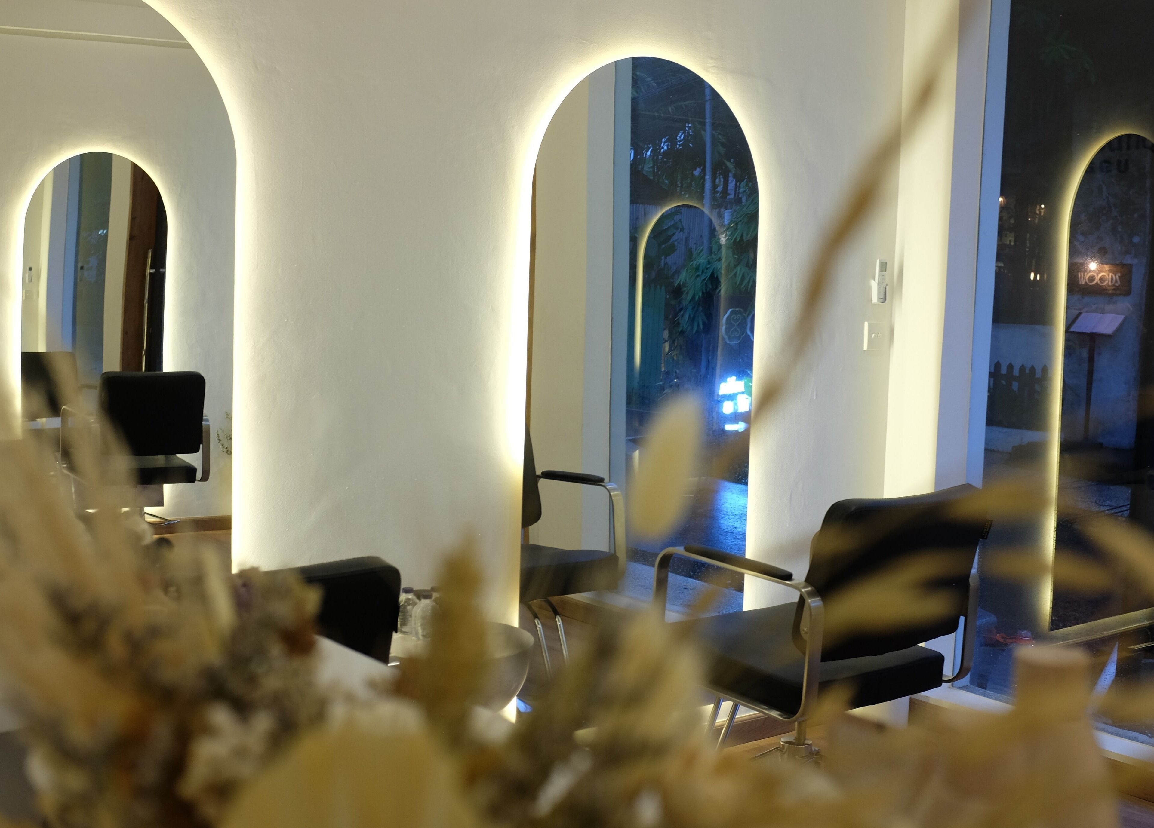 Stylish interior of Blowdry Boutique Canggu, Bali, Bali, ID showcasing chairs and mirrors with warm lighting.