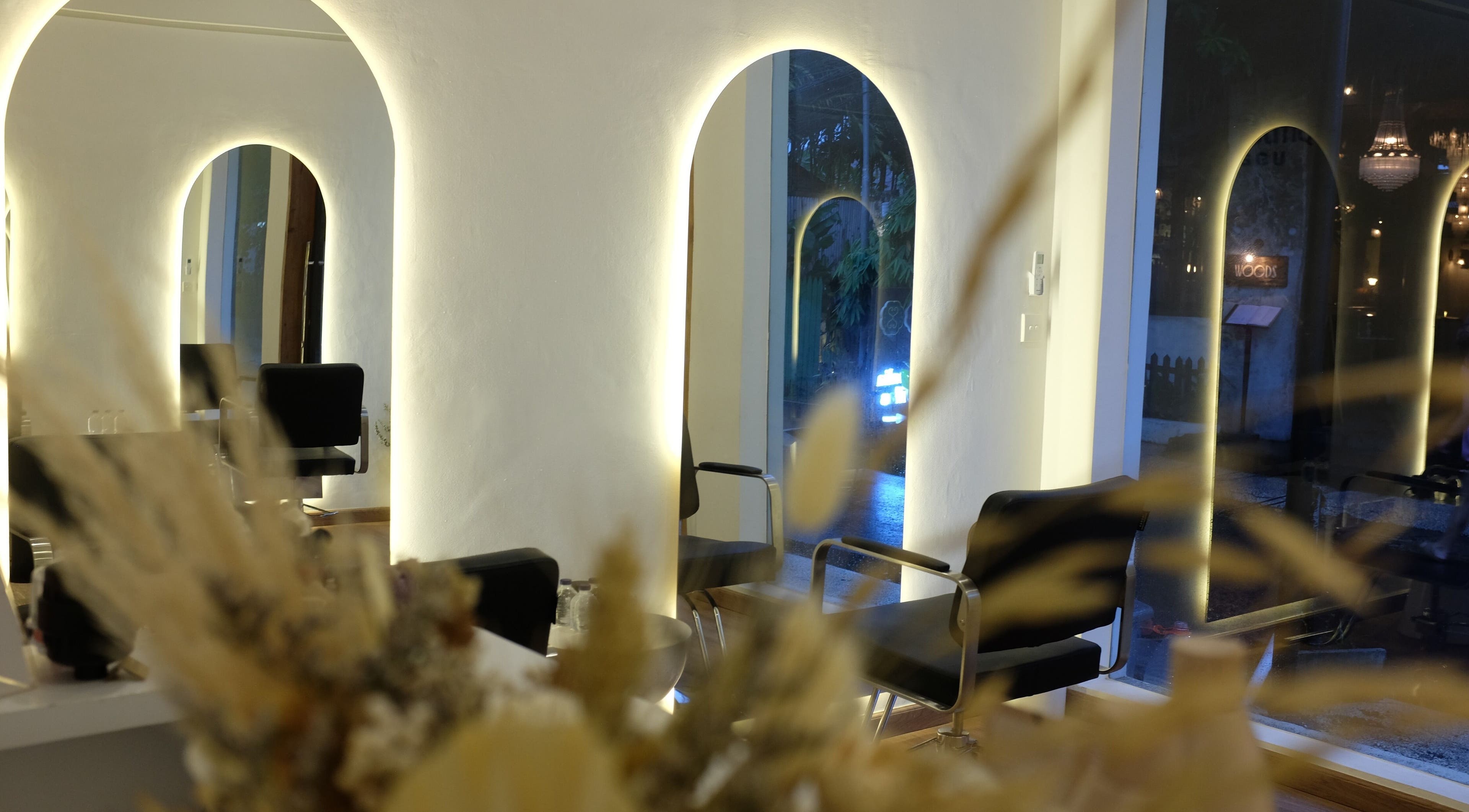 Stylish interior of Blowdry Boutique Canggu, Bali, Bali, ID showcasing chairs and mirrors with warm lighting.
