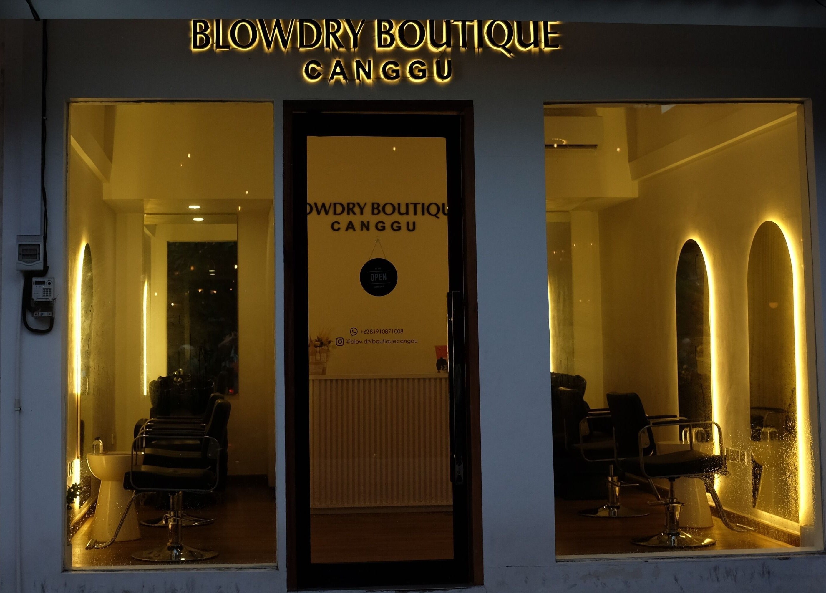 Cozy evening view of Blowdry Boutique Canggu, Bali, Bali, ID with warm lighting and chic salon chairs.