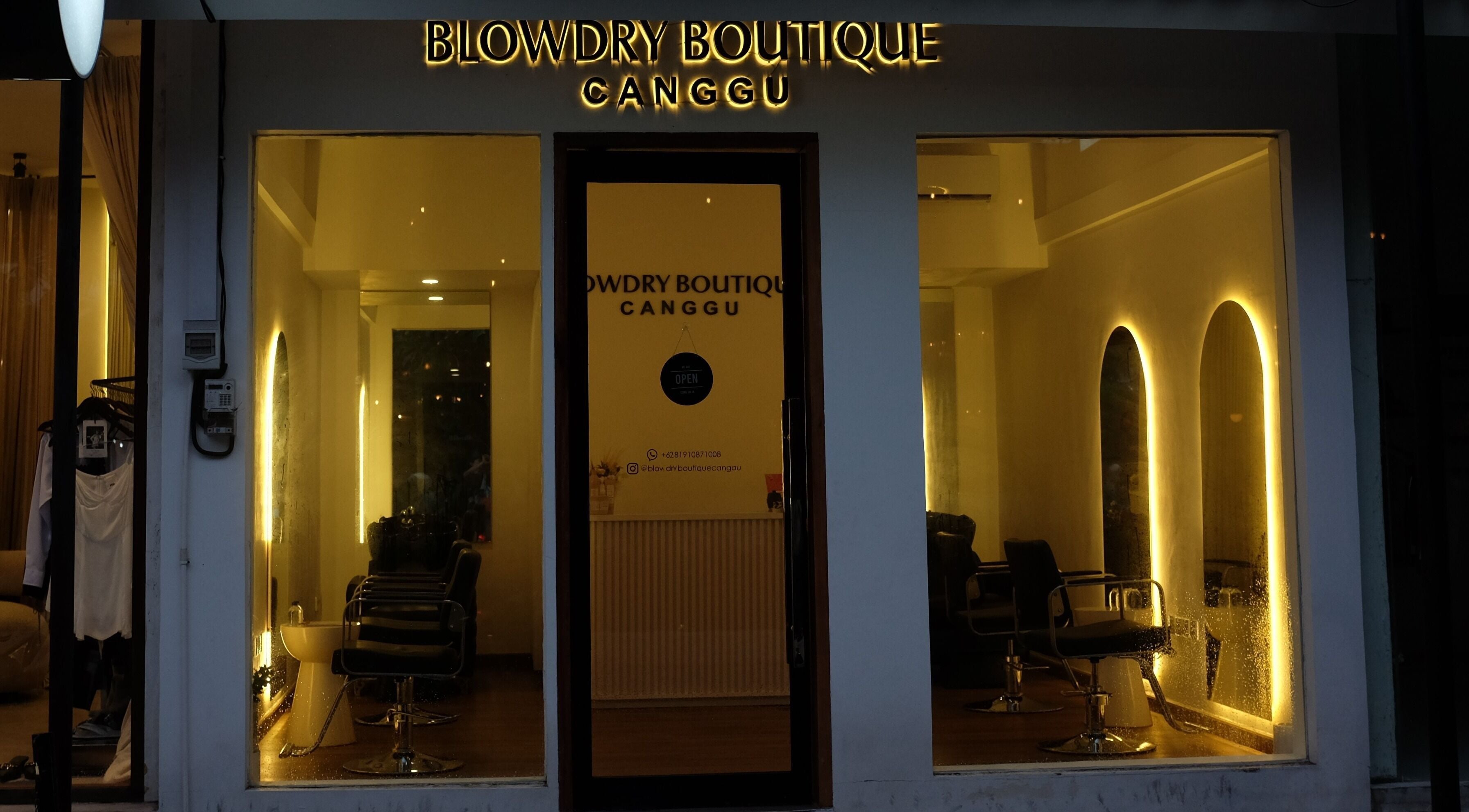 Cozy evening view of Blowdry Boutique Canggu, Bali, Bali, ID with warm lighting and chic salon chairs.
