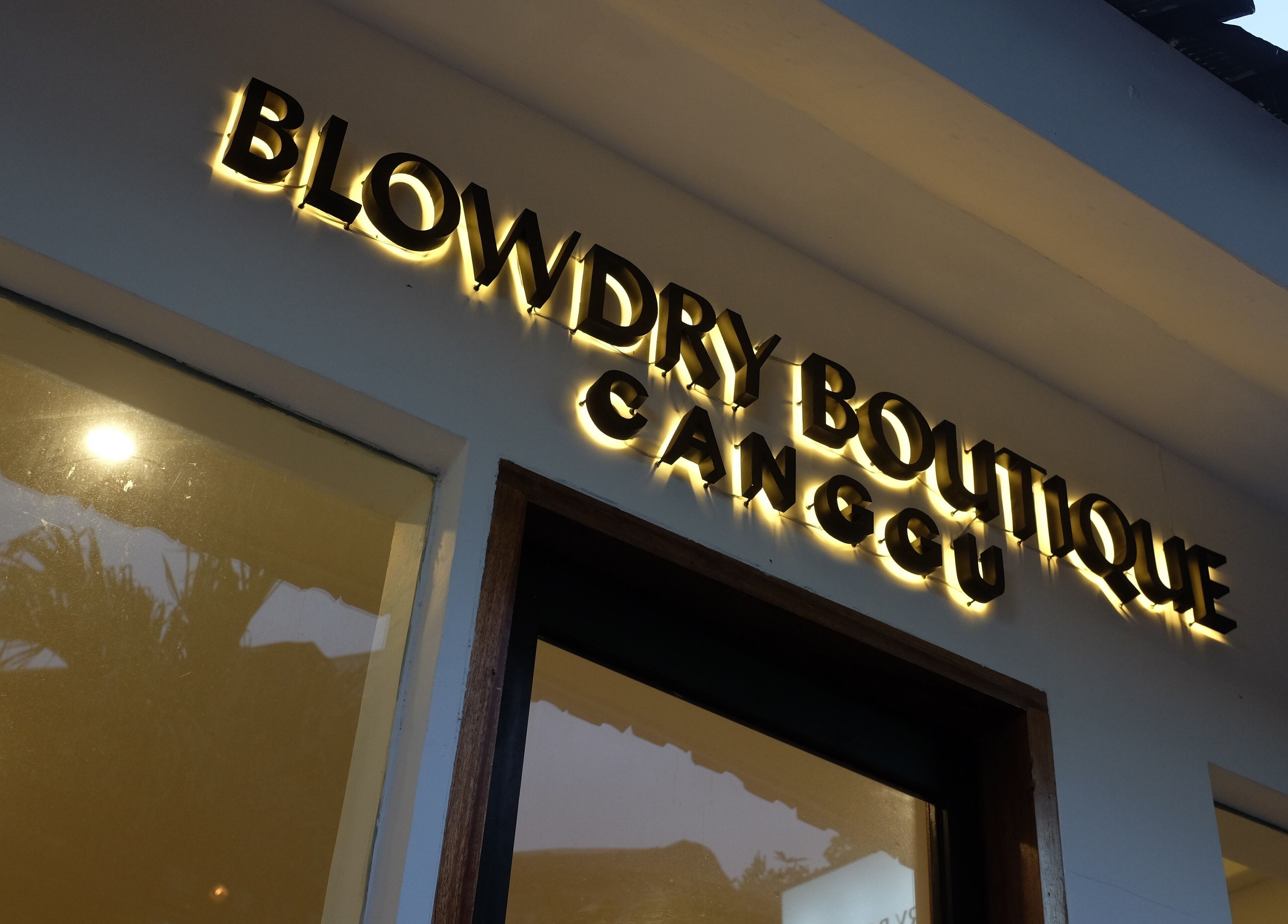 Illuminated Blowdry Boutique Canggu sign in Bali, Bali, ID at dusk.