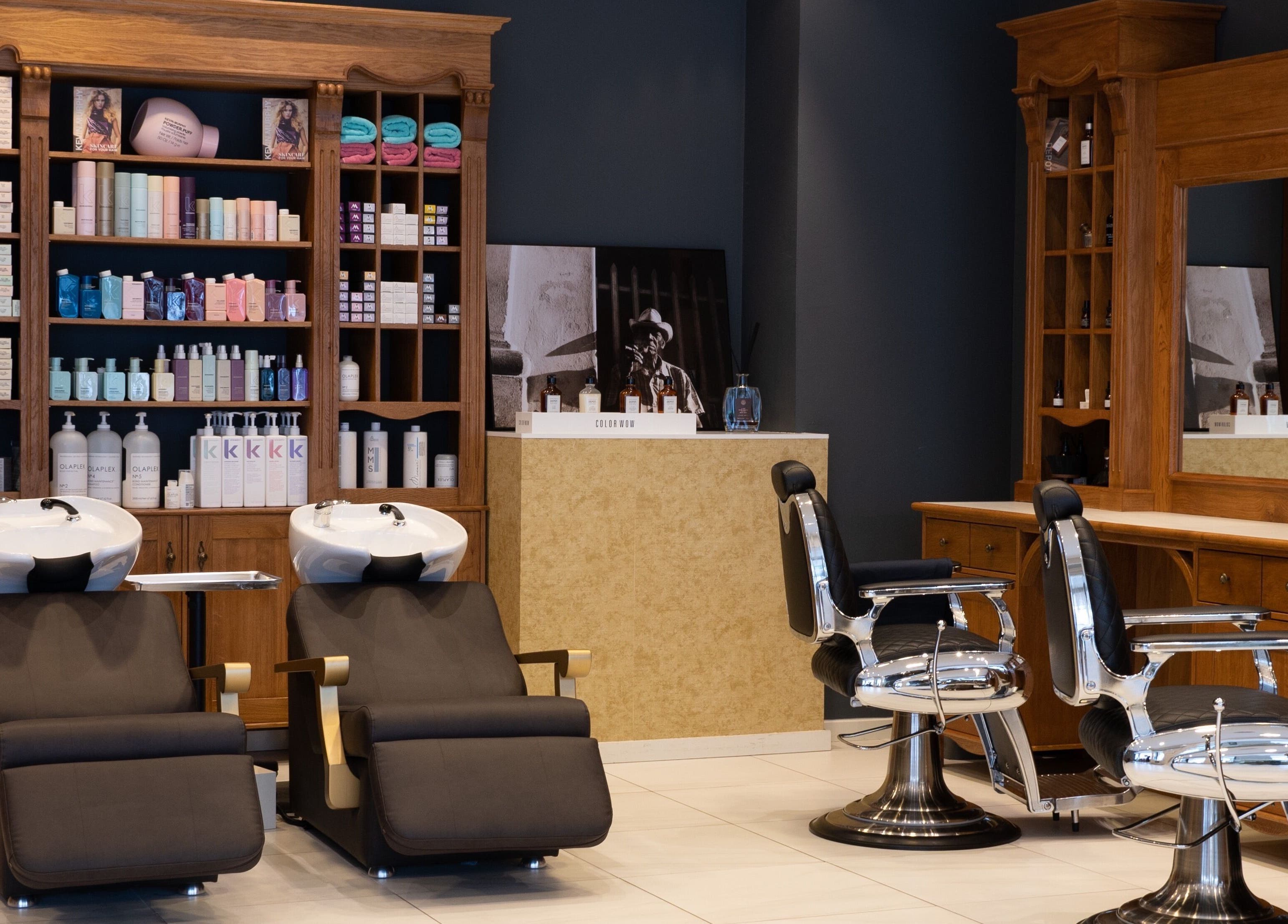 Binnenzicht van Blessed Cuts in Boxtel, Noord-Brabant, NL met retro kappersstoelen en producten op planken.