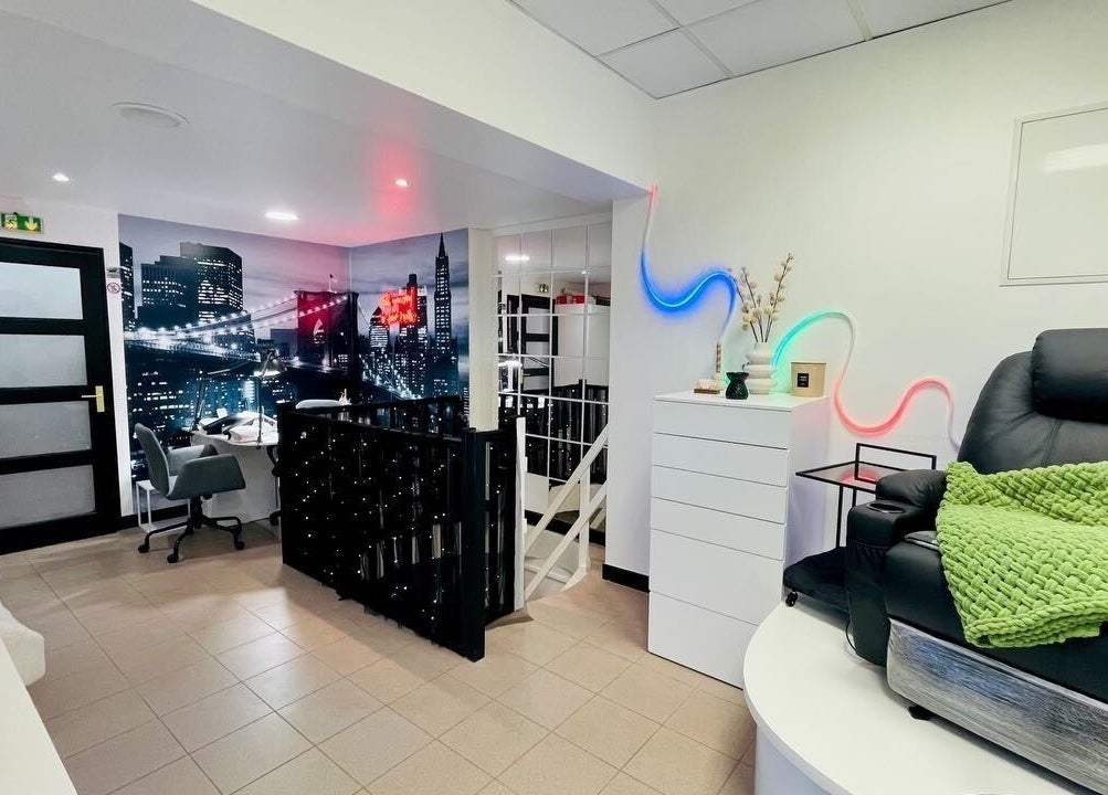 Intérieur moderne de Beauty Salon Estetika à Puteaux, FR, avec fauteuils confortables et décor urbain élégant.