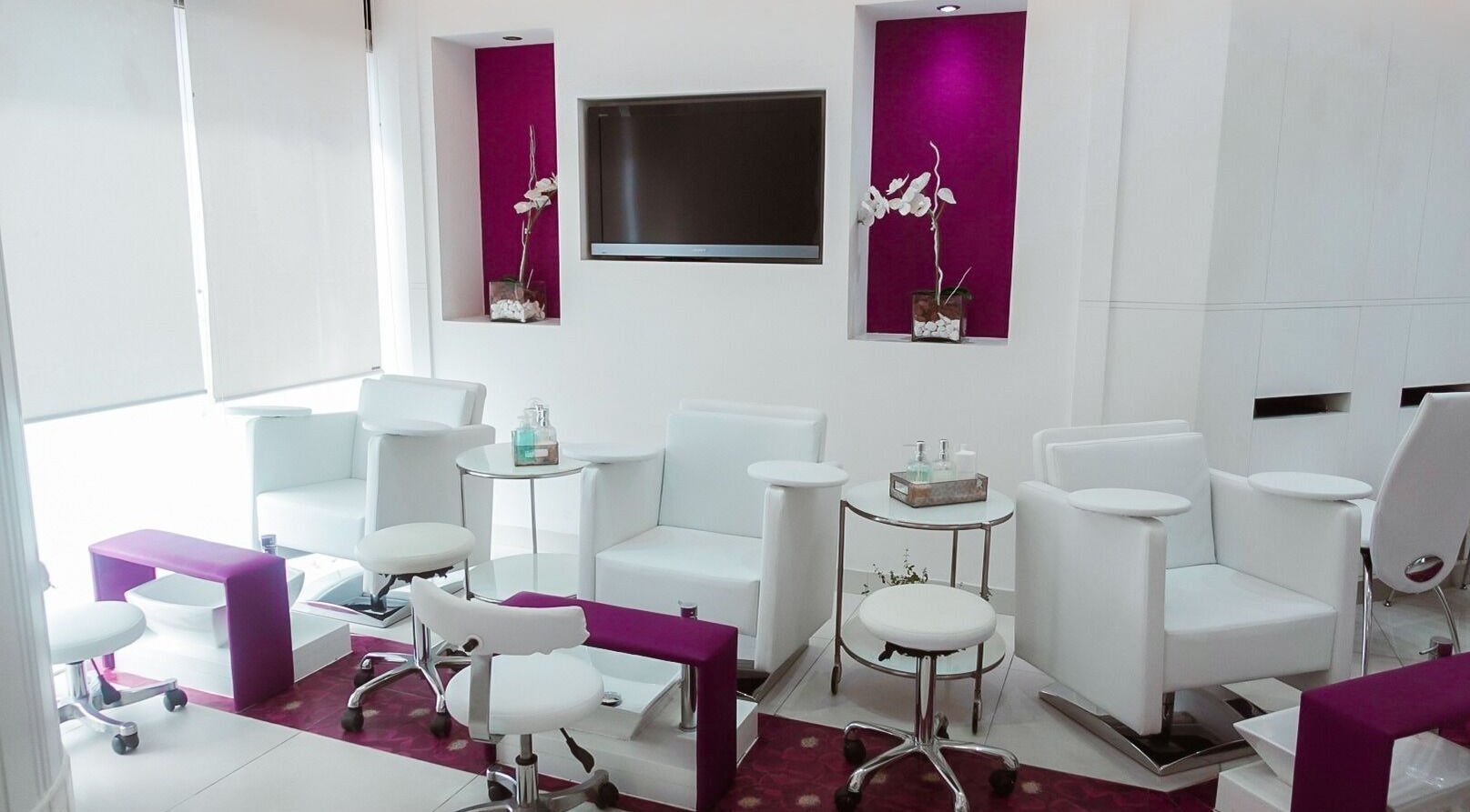 Elegant nail station at Nails Couture Ladies Salon in Abu Dhabi, featuring plush white chairs and vibrant accents.
