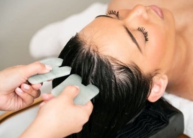 Woman receives a scalp massage with jade stones at Spa Eves | Scalp Spa + Massage in Austin, Texas, US.