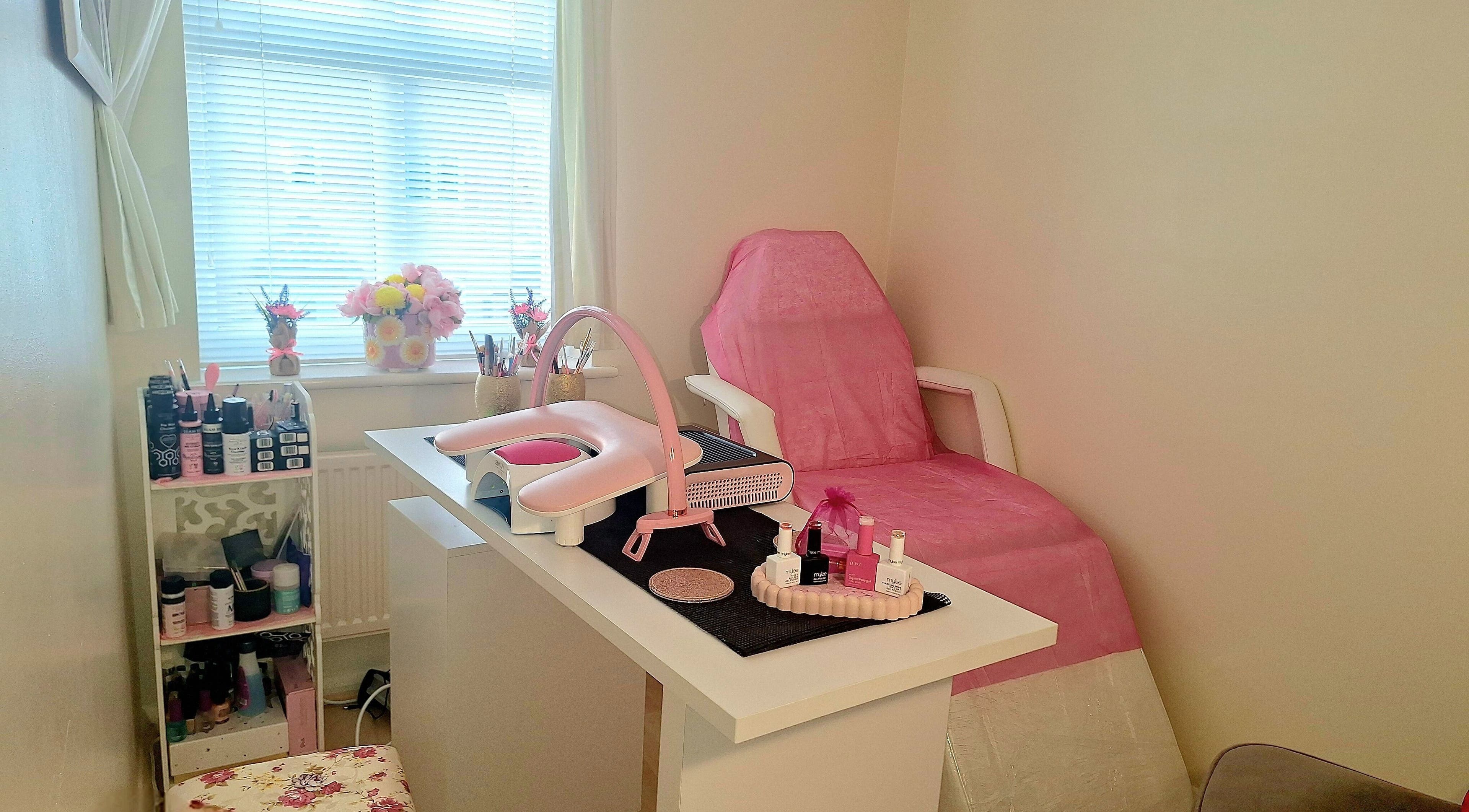 Nail station at Glam Beauty Room, Whetstone, England, GB showcasing elegant pink decor and manicure tools.