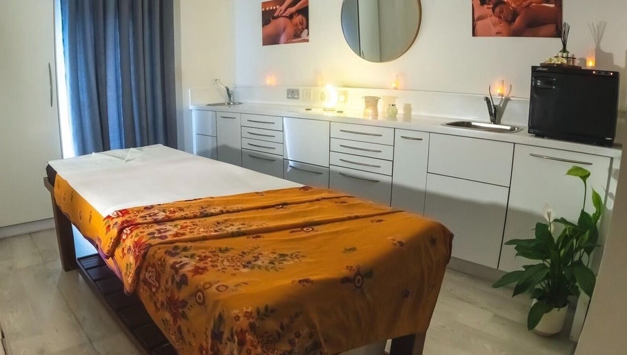 Relaxing massage room at Yoganic Thai Spa and Massage, London, England, GB with a decorated treatment bed.