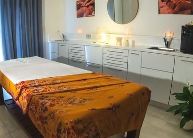 Relaxing massage room at Yoganic Thai Spa and Massage, London, England, GB with a decorated treatment bed.