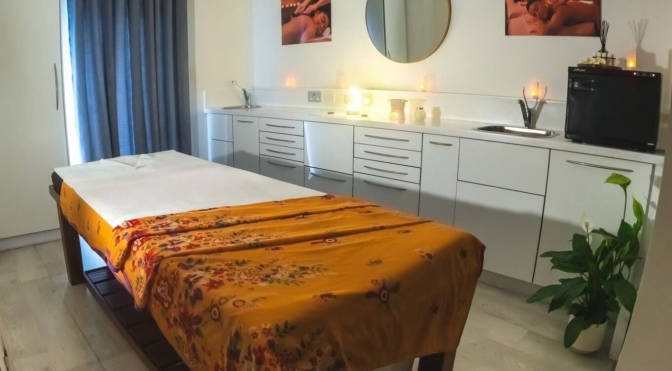 Relaxing massage room at Yoganic Thai Spa and Massage, London, England, GB with a decorated treatment bed.