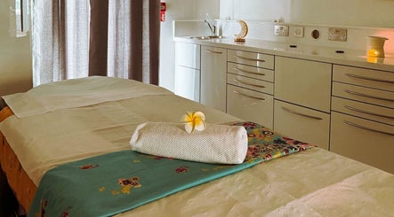 Relaxing massage table at Yoganic Thai Spa and Massage, London, England, GB, set with flower and towel.